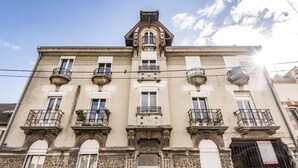 Un edificio histórico con fachada simétrica, varios balcones y una entrada central.