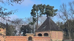 A small, brick structure with a conical roof and arched openings, surrounded by a patterned wall and a grassy area. - Spacious renovated lodge near Moulins for 10 p, pets welcome, WiFi (Trévol)