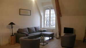 A living room with a sofa, two armchairs, a coffee table, a lamp, a TV, and a window with curtains. - Spacious renovated lodge near Moulins for 10 p, pets welcome, WiFi (Trévol)