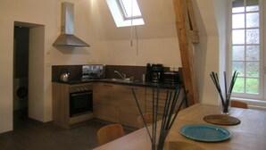 A modern kitchen with a skylight, a dining table with chairs, and a view of the outdoors. - Spacious renovated lodge near Moulins for 10 p, pets welcome, WiFi (Trévol)