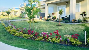 A modern hotel with a well-maintained lawn and colorful flower beds.