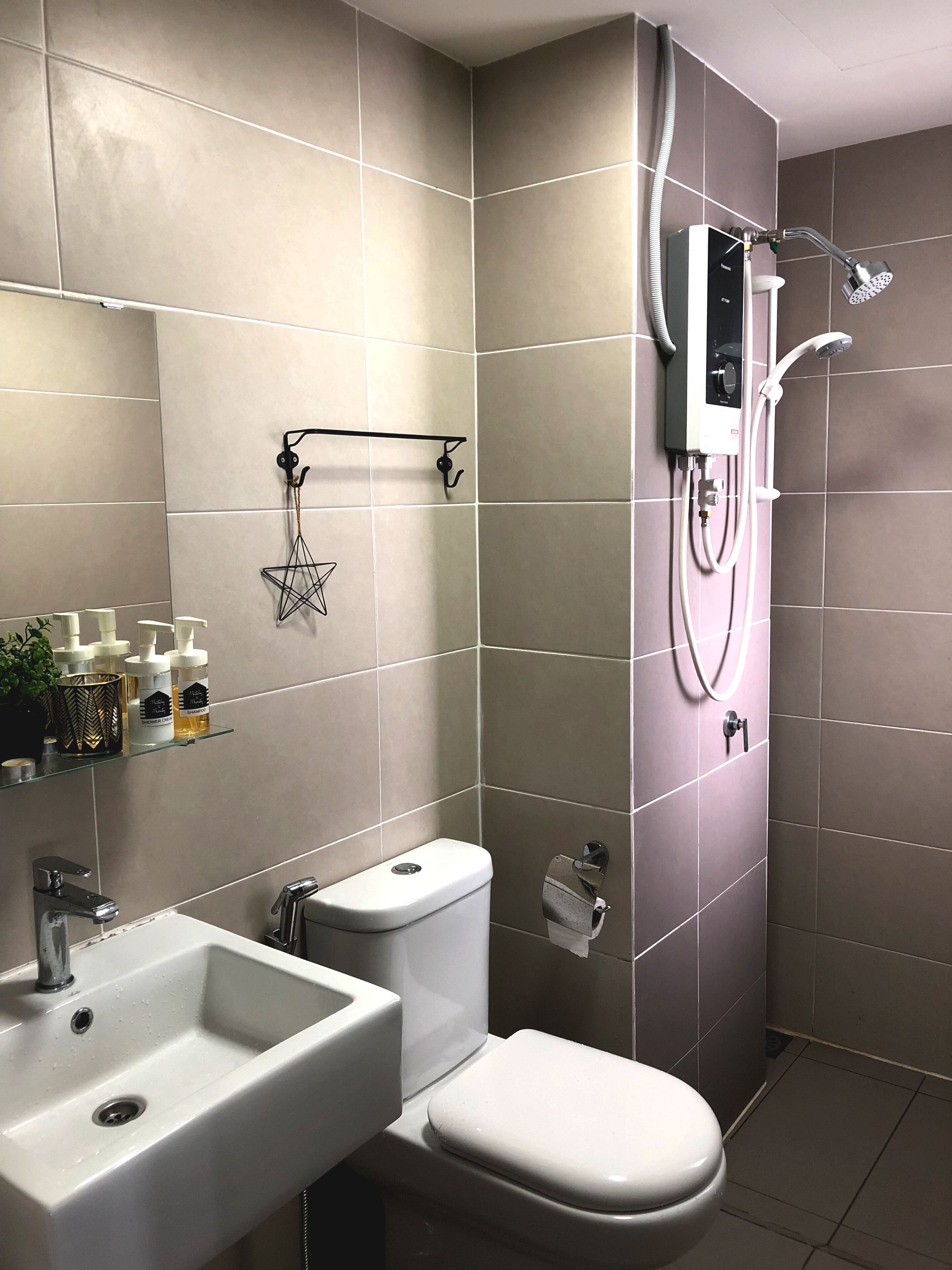 A modern bathroom with a toilet, sink, and shower.