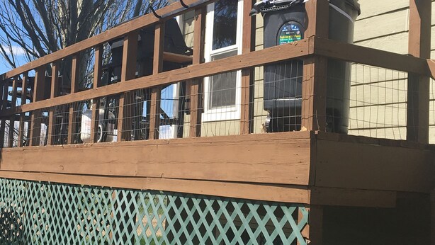 A wooden deck with a lattice fence, a window with a grill, and a tree in the background. - Sage House- in town with LOTS of space (Ennis)