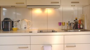Eine moderne Küche mit Kaffeemaschine, Wasserkocher und verschiedenen Gewürzen.