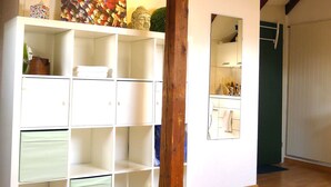 Ein Schlafzimmer mit einem Bett, einem weißen Kleiderschrank, einem Gemälde und einer Holzbalkenkonstruktion.