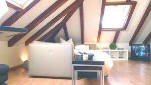 Ein Schlafzimmer mit Bett, Sofa, Fernseher und Lampe.