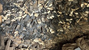 Een kamer met een schuine balkenplafond en een grote stapel hout.