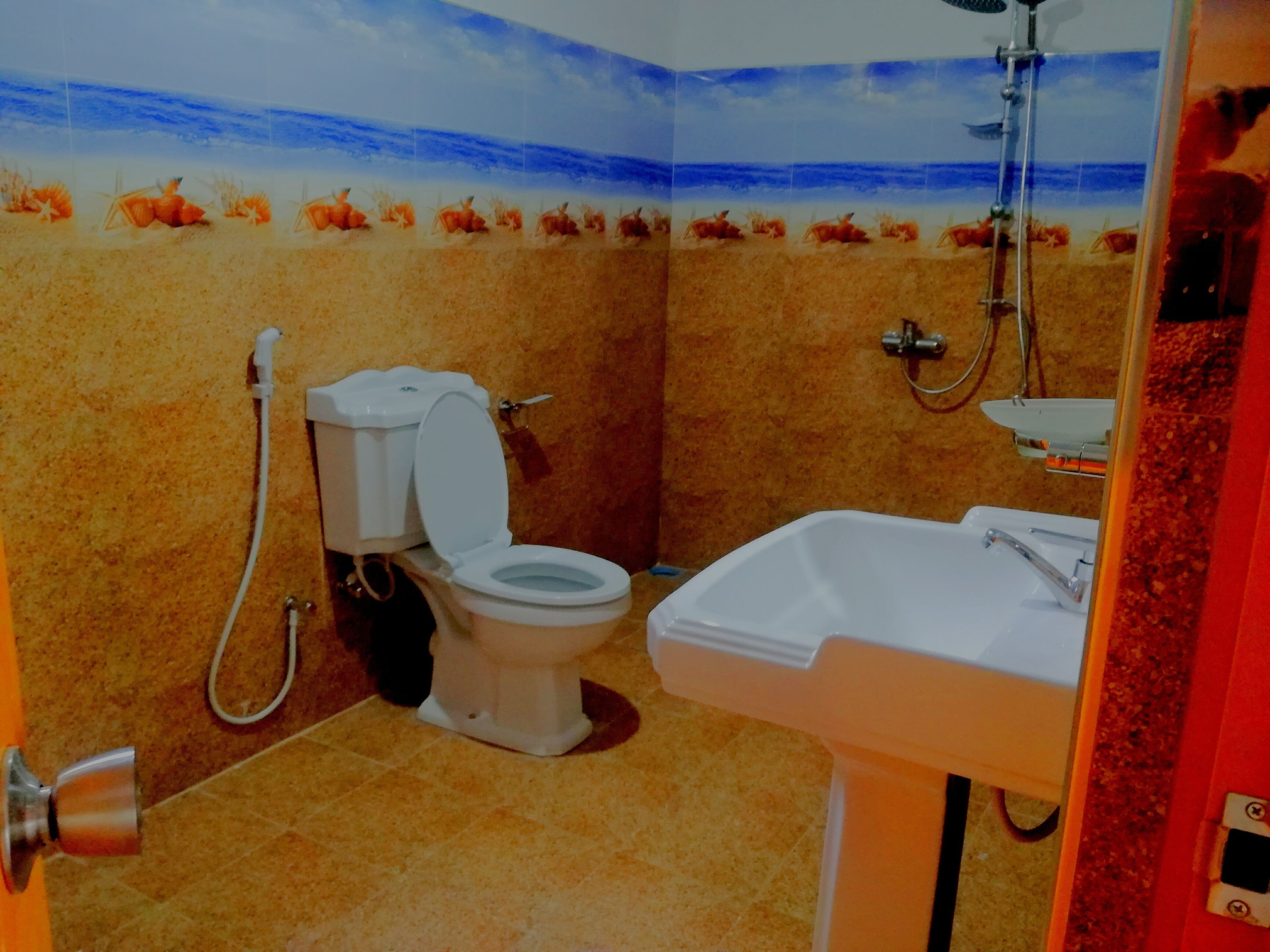 Une salle de bain comprenant des toilettes, un lavabo et une douche.