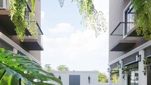 A modern building with a swimming pool, surrounded by greenery and white walls. - Hotel Matana (Chiang Mai)