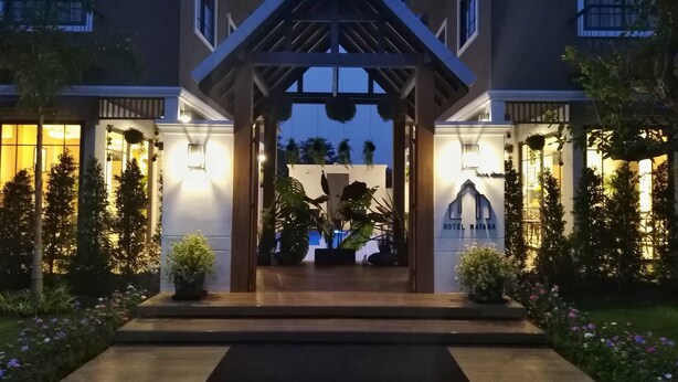 A hotel entrance with a covered walkway, potted plants, and a well-lit facade. - Hotel Matana (Chiang Mai)