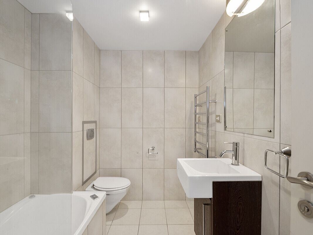 Ein modernes Badezimmer mit Badewanne, Toilette und Waschbecken.