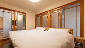Un dormitorio con una cama grande, un armario de madera y una mesita de noche.