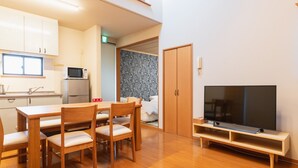 Un apartamento moderno con comedor, kitchenette y televisor.