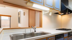 Una cocina moderna con un lavamanos de acero inoxidable, estufa y armarios azules.