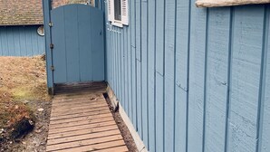 A blue wooden house with a wooden deck leading to a blue door. - An Onekama gem. Short walk to a quiet beach. (Onekama)