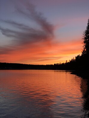 A sunset over a calm lake with a forested shoreline. - Waterfront house in Bayview! Boating, fishing, amazing views, 12mi to Silverwood (Bayview)