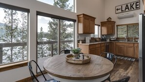 A kitchen with wooden cabinets, a round dining table with chairs, and a view of a lake. - Waterfront house in Bayview! Boating, fishing, amazing views, 12mi to Silverwood (Bayview)