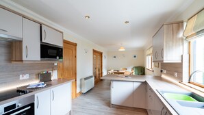 Een moderne keuken met inbouwapparatuur, houten kastjes en een centraal eiland.