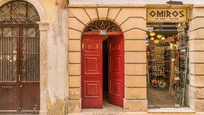 Una tienda llamada "OMIROS", con una puerta roja y un letrero encima.