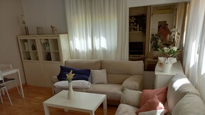 A living room with a beige sofa, a white coffee table, and a white cabinet with glass doors. - Chalet with mountain views and private pool, ideal for families.  (viladecavalls)