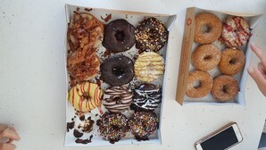 To kasser med forskelligt slik og donuts på et bord.