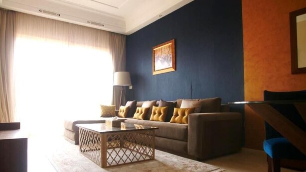 A living room with a sofa, coffee table, and a lamp. - Residence Genegelis 4055 (Marrakech)