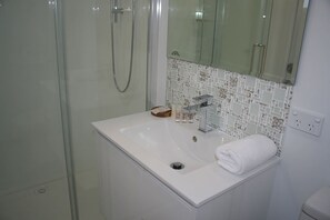 Superior huis, uitzicht op strand | Badkamer | Een douche, een haardroger, handdoeken, zeep