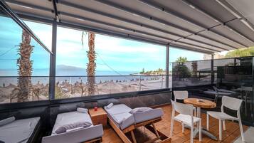 Enjoy a panoramic view of the beach and sea from this room's large windows.