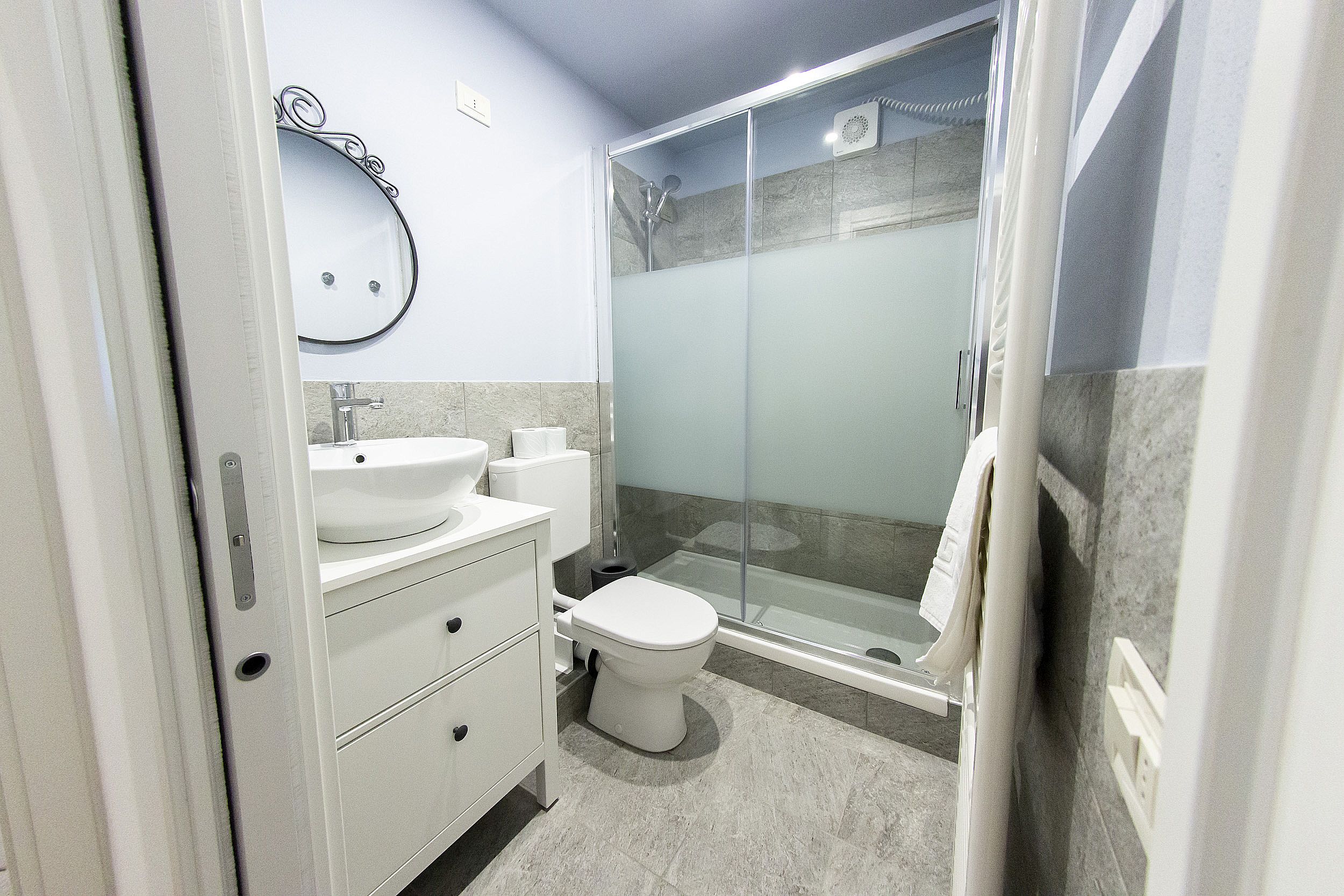 A modern bathroom with a toilet, sink, and shower.