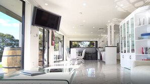 Una sala moderna con una mesa de centro de cristal, un sofá blanco y una escultura decorativa de metal.