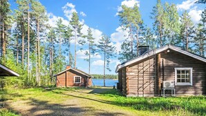 Eine Holzhütte mit einer kleinen Veranda und Blick auf einen See.