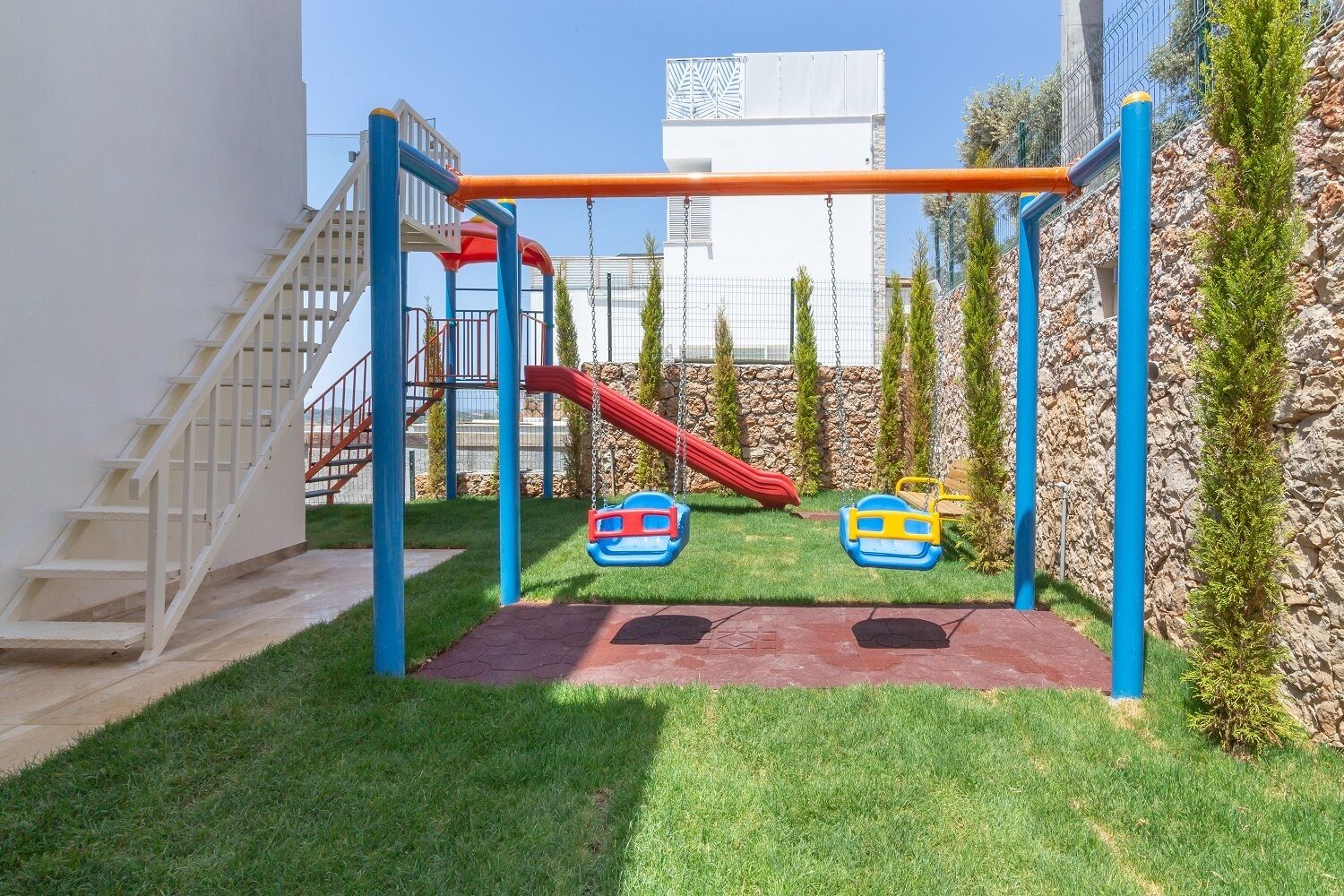 A playground with a slide, swings, and a climbing structure.