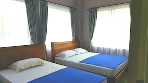 A hotel room with two single beds, each with a wooden headboard and white bedding. - Hotel Amalia Malioboro (Yogyakarta)