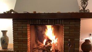 Una chimenea de ladrillo con fuego a la vista, un jarrón y un candelabro.