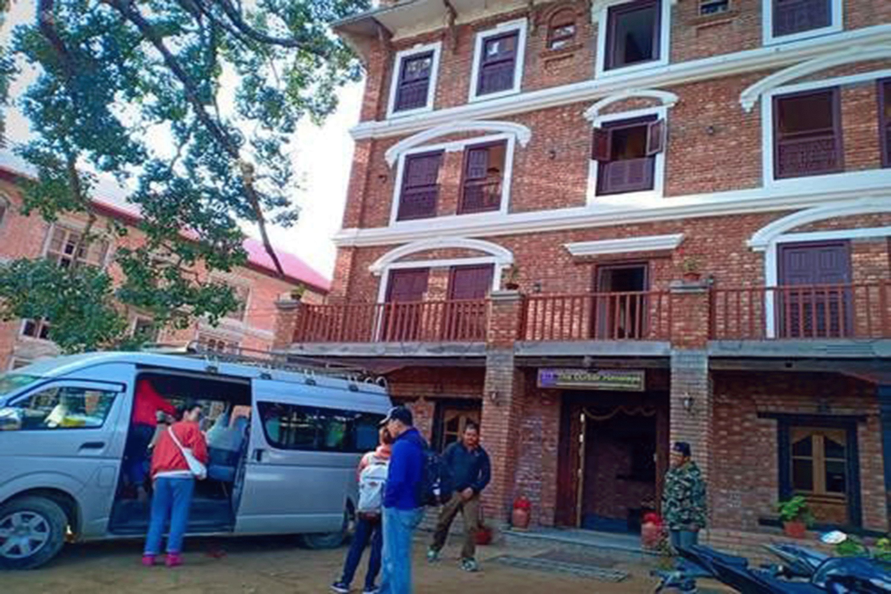 Un edificio de ladrillo de varios pisos con un balcón en el segundo piso.