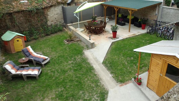 A backyard with a covered patio, a playhouse, lounge chairs, and a wooden shed. - Contemporary 3-level house in Vaumas, near Moulins (Vaumas)
