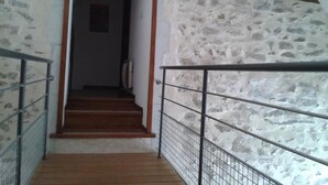 A staircase with a stone wall on one side and a wooden floor. - Modern Rustic Cottage with Pool and Pets Allowed (Chirat-l'Église)
