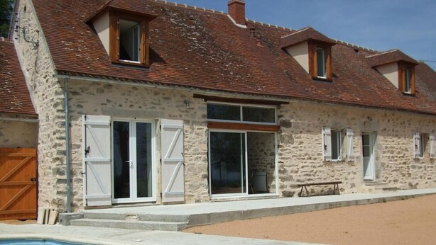 A stone building with a swimming pool, large windows, and a wooden door. - Modern Rustic Cottage with Pool and Pets Allowed (Chirat-l'Église)