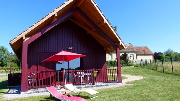 A wooden cabin with a red roof and a covered patio area. - Cottage in Bourbonnais countryside with private garden (Meillard)