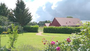 A rural landscape with a red barn, a garden with roses, and a swing set. - Cottage in Bourbonnais countryside with private garden (Meillard)