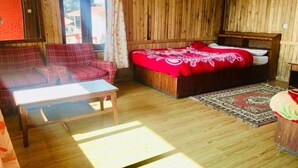 A wooden-paneled room with a bed, a sofa, and a small table. - Hotel Galaxy View Tower (Baluwapati Deupur)