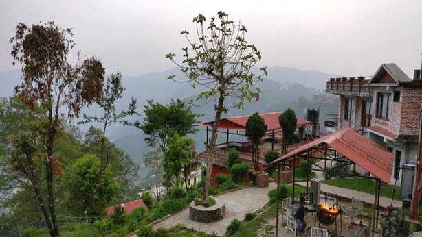 A hillside property with a patio area, outdoor seating, and a view of the surrounding landscape. - Hotel Galaxy View Tower (Baluwapati Deupur)