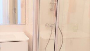 A modern bathroom with a glass-enclosed shower, a white vanity, and a large mirror. - Fantastic 2 bed 2 bath beachside penthouse with pool and parking (Marbella)