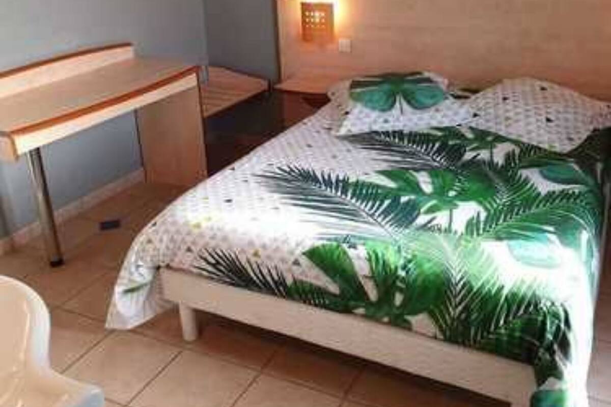 Ein Schlafzimmer mit einem Bett, einem Schreibtisch und einem Nachttisch.
