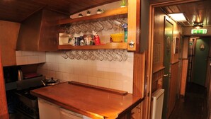 Une cuisine avec des meubles de rangement en bois, un plan de travail et un porte-ustensiles fixé au mur.