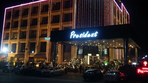 A hotel with a prominent 'President' sign, multiple floors, and string lights. - Hotel President (Jalandhar)