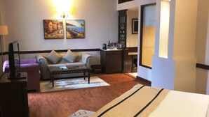 A hotel room with a bed, a sofa, a desk, and a TV. - Hotel President (Jalandhar)