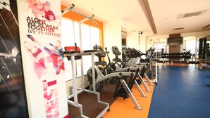 A gym with exercise equipment, a large mirror, and a motivational poster. - Hotel President (Jalandhar)