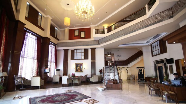 A spacious lobby with a grand chandelier, a staircase, and a reception desk. - Hotel President (Jalandhar)