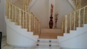 A spiral staircase with white walls and a tiled floor. - Emerald House (Dar es Salaam)